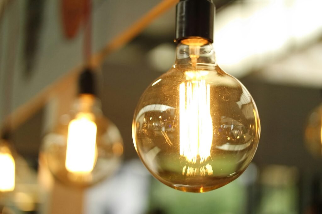 Engineering Services. Building Science. A close-up of a glowing vintage Edison bulb creating a warm atmosphere.